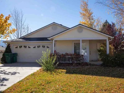 Single-storey Northern Nevada tract house with gable vents, stucco walls and a covered entry porch in late autumn