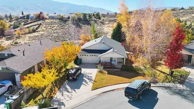 Aerial view of a Northern Nevada cul-de-sac of single-storey homes with sagebrush hills behind, in autumn