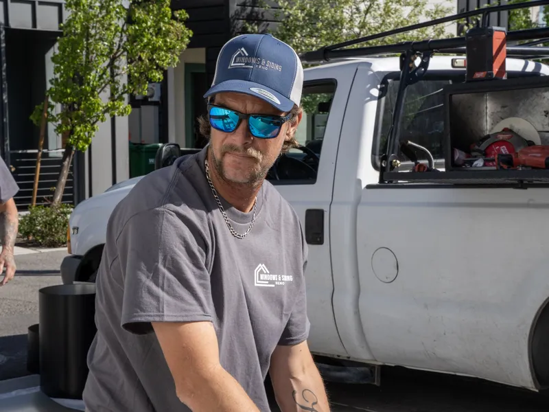 Crew member at the open toolbox of a branded work truck
