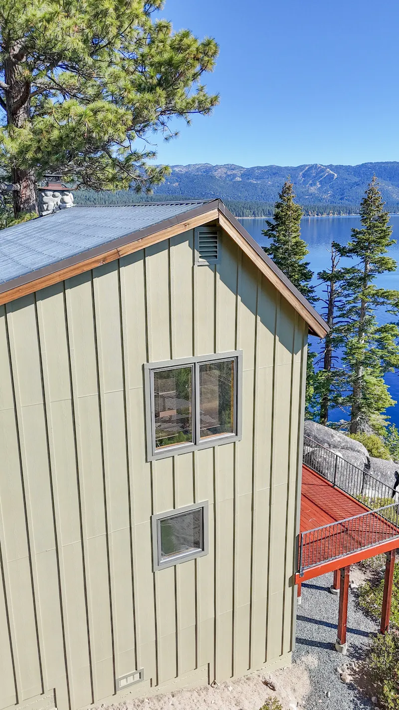 Gable end with fresh board-and-batten siding and new dual-pane windows, Lake Tahoe behind
