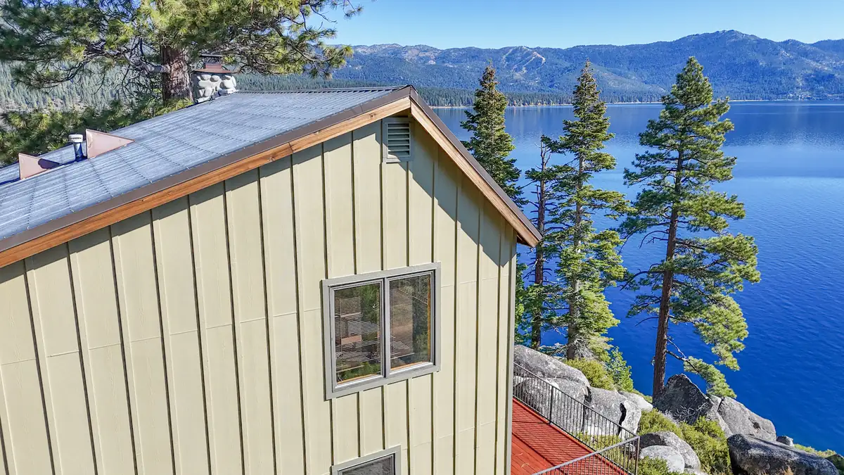 Corner of a board-and-batten gable with a new picture window overlooking Lake Tahoe