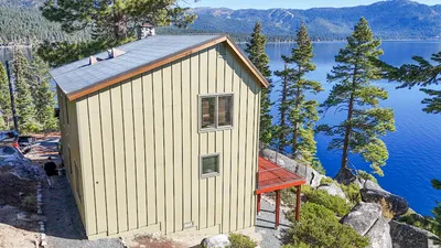 Drone view over a re-sided roofline and deck toward Lake Tahoe