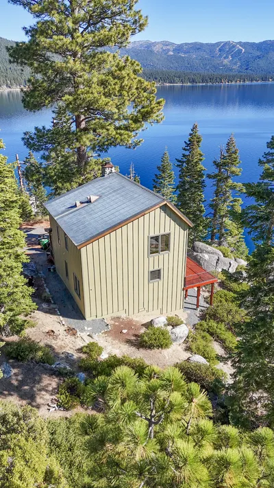 Aerial of a re-sided house and deck above the Lake Tahoe shoreline