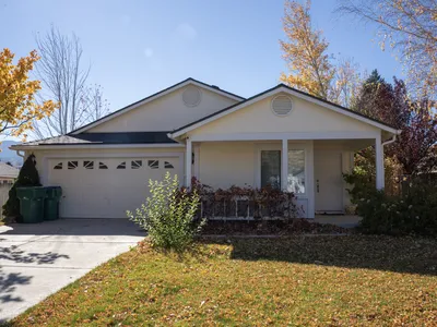 Front elevation of a ranch house with new yellow board-and-batten siding and white trim