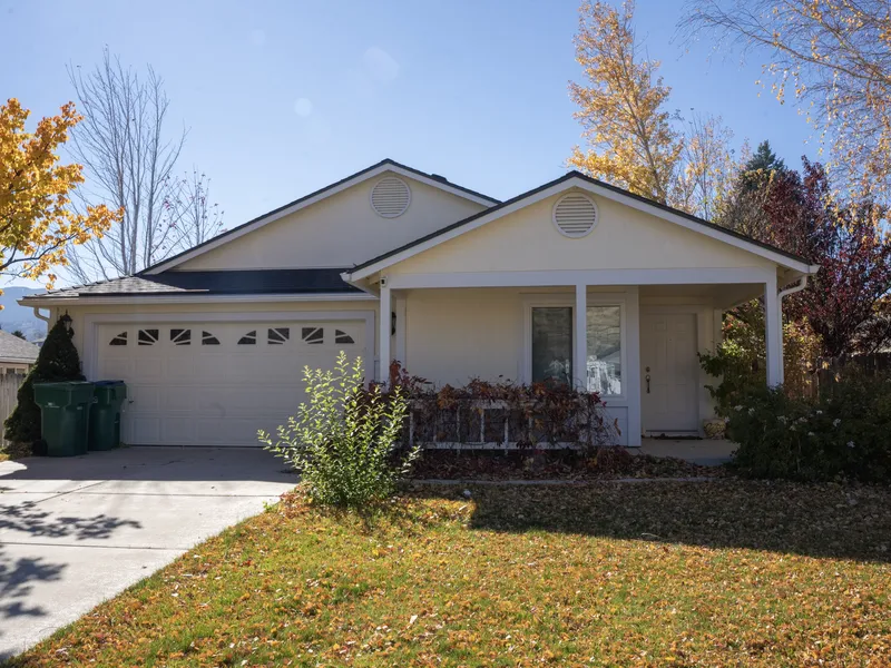 Front elevation of a ranch house with new yellow board-and-batten siding and white trim